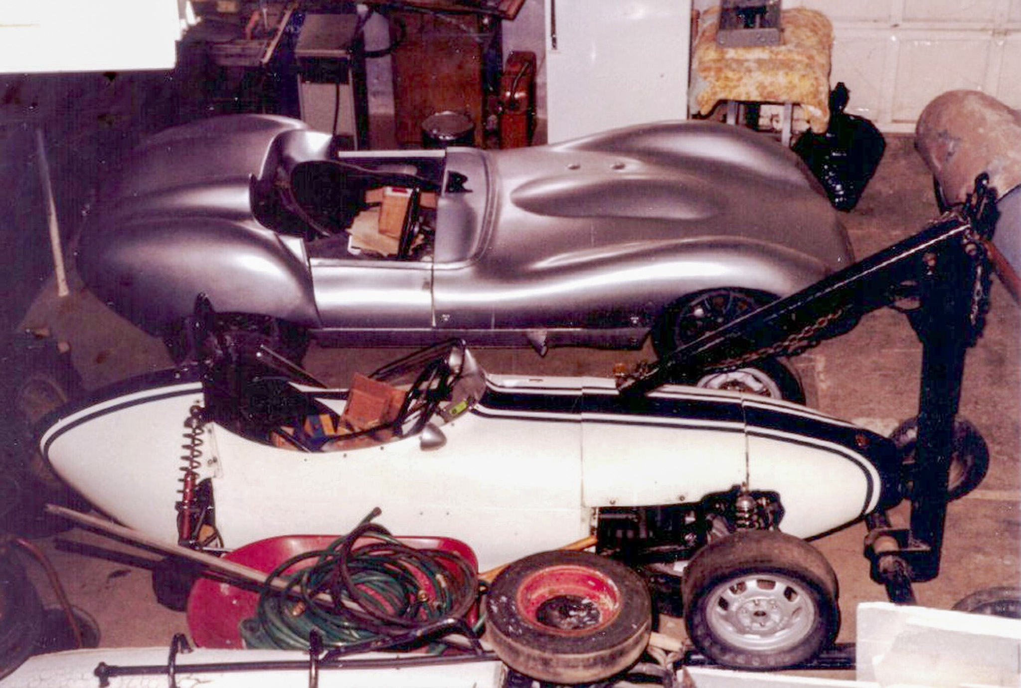 Our silver 1959 Lola Mk1 sports racer and our blue and white BMC Formula race car in Batavia workshop, 1982.